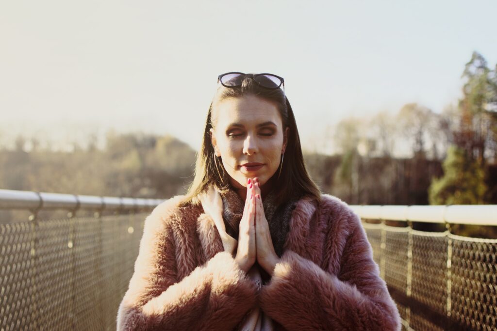 женщина молится на природе - важно быть благодарным Богу