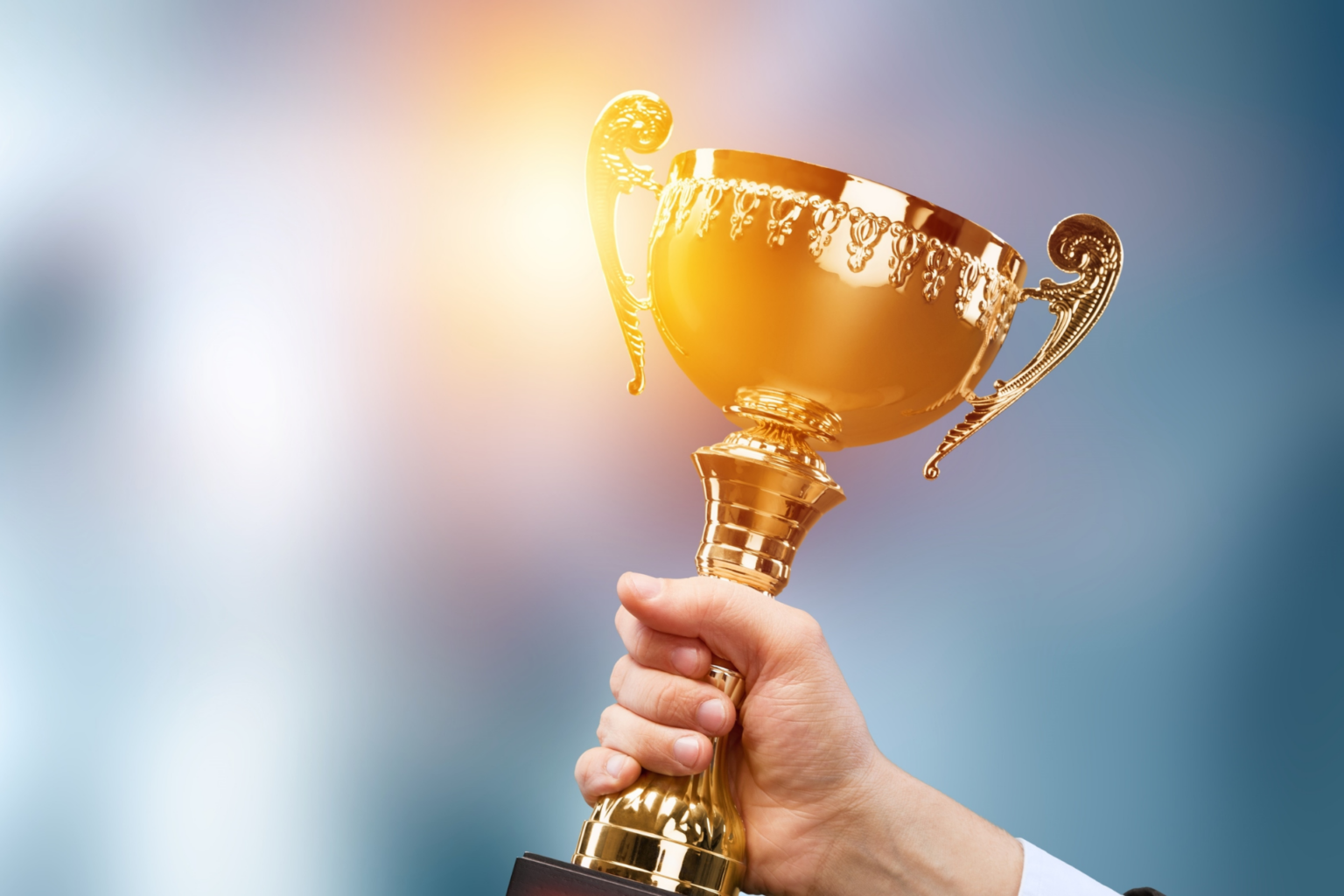 человек с медалью. кубок с юбилеем. красивый кубок. блестящий успех выдающаяся победа. золотые звезды фон.